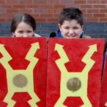 Kids holding roman shields